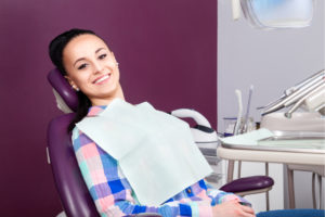 young women sitting in dental chair smiling