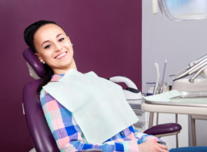 young women sitting in dental chair smiling